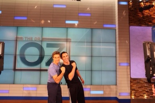 Jorge Cruise and Dr. Mehmet Oz in front of the jumbotron on The Dr. Oz Show set